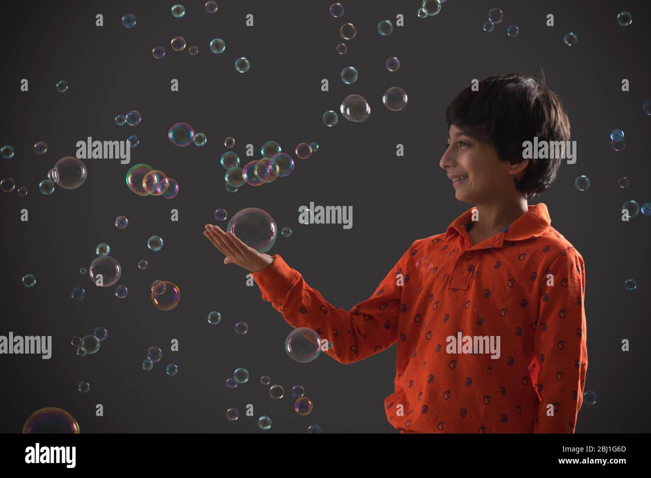 portrait of a young boy holding a bubble in her hand Stock Photo