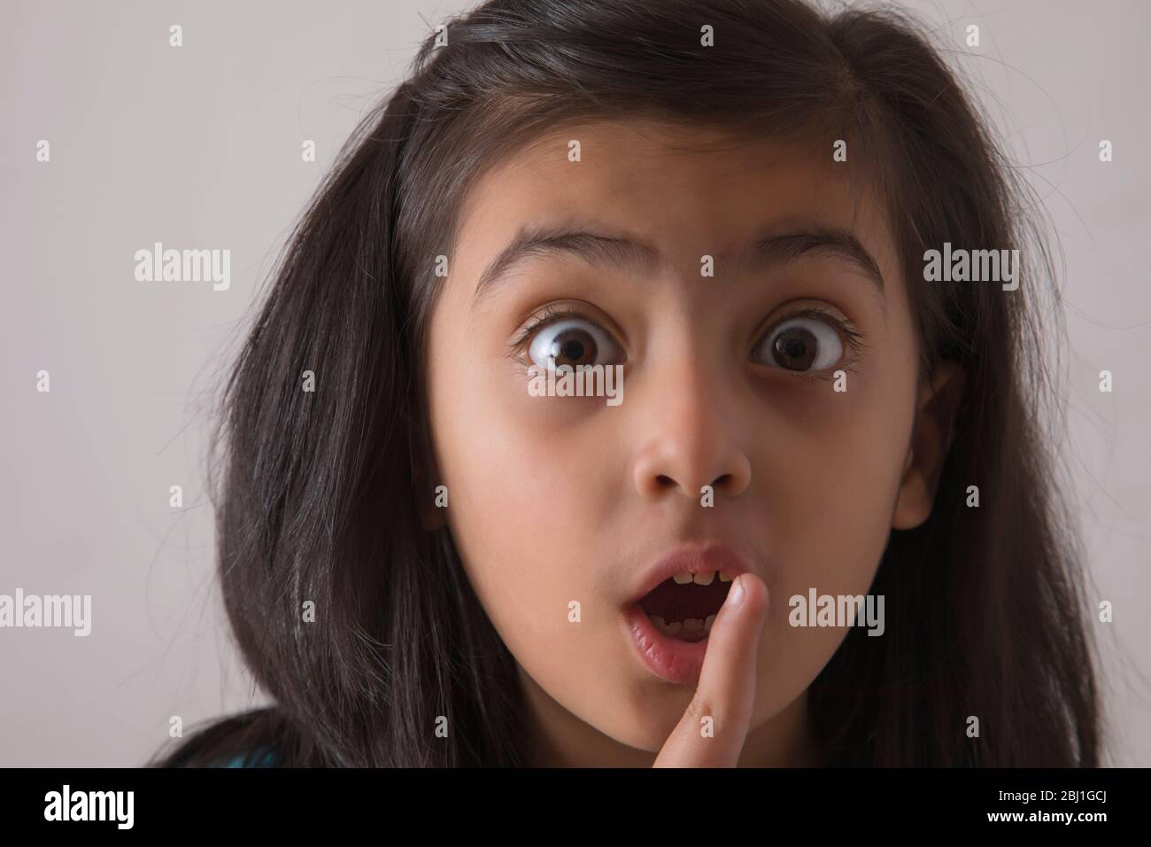 close up of a young girl with finger on her lips Stock Photo - Alamy