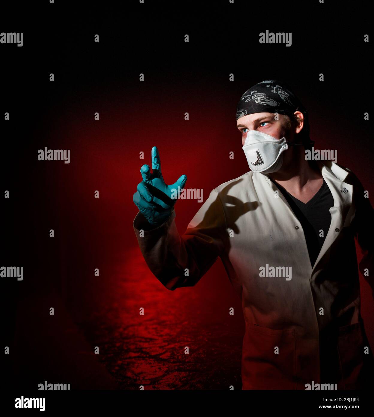 A 'doctor' wearing a face mask and gloves in a very dramatic setting. Stock Photo