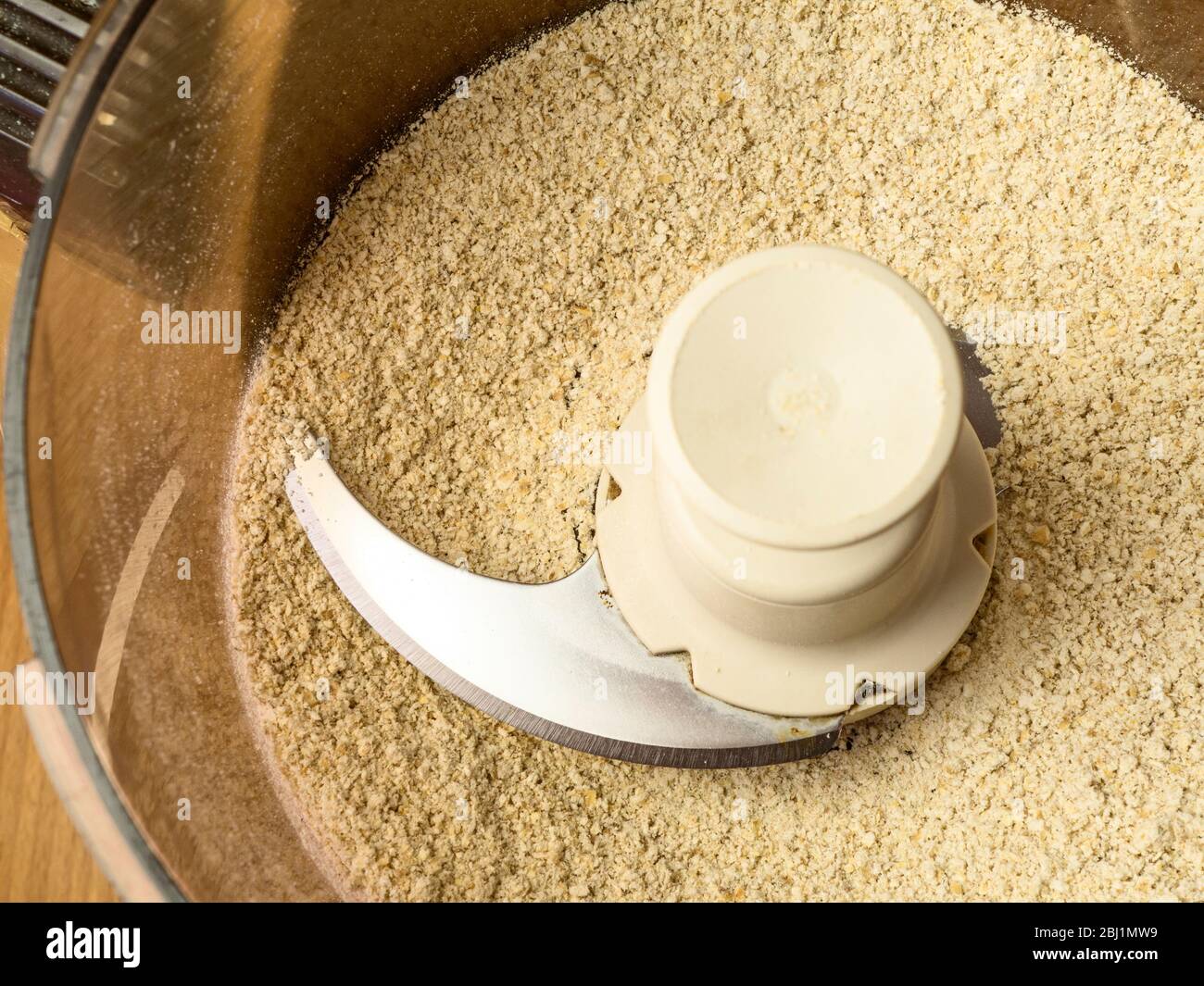 Making oat flour from rolled oats in a food processor for use in oat bread Stock Photo