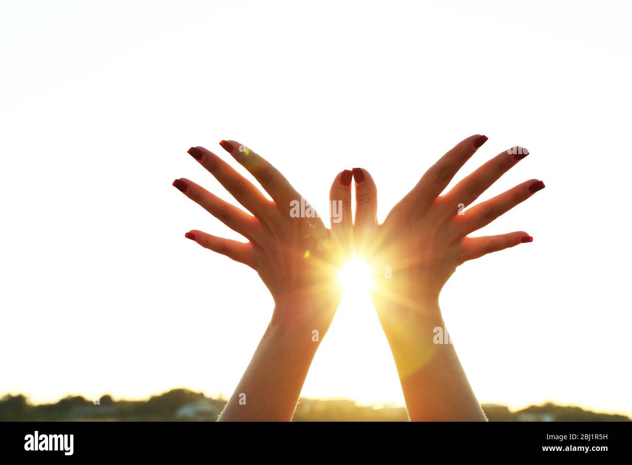 Female hands on sunny sky background Stock Photo - Alamy