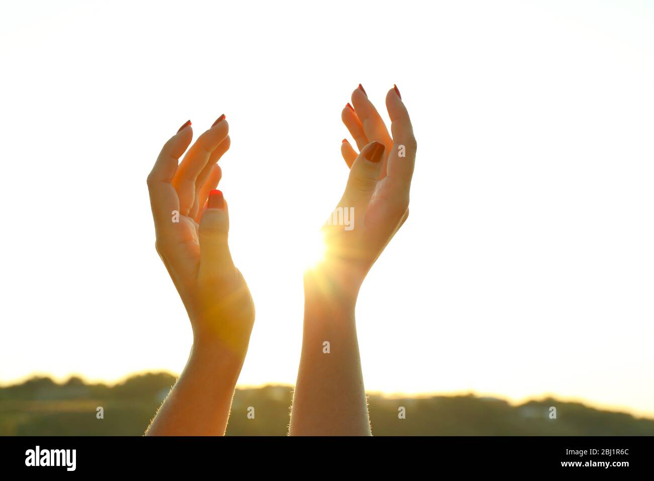 Female hands on sunny sky background Stock Photo - Alamy