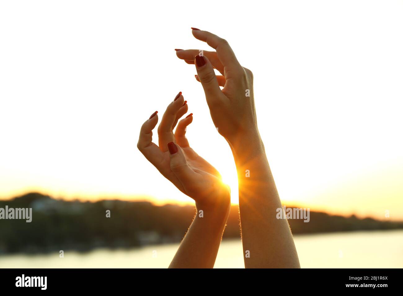 Female hands on sunny sky background Stock Photo - Alamy