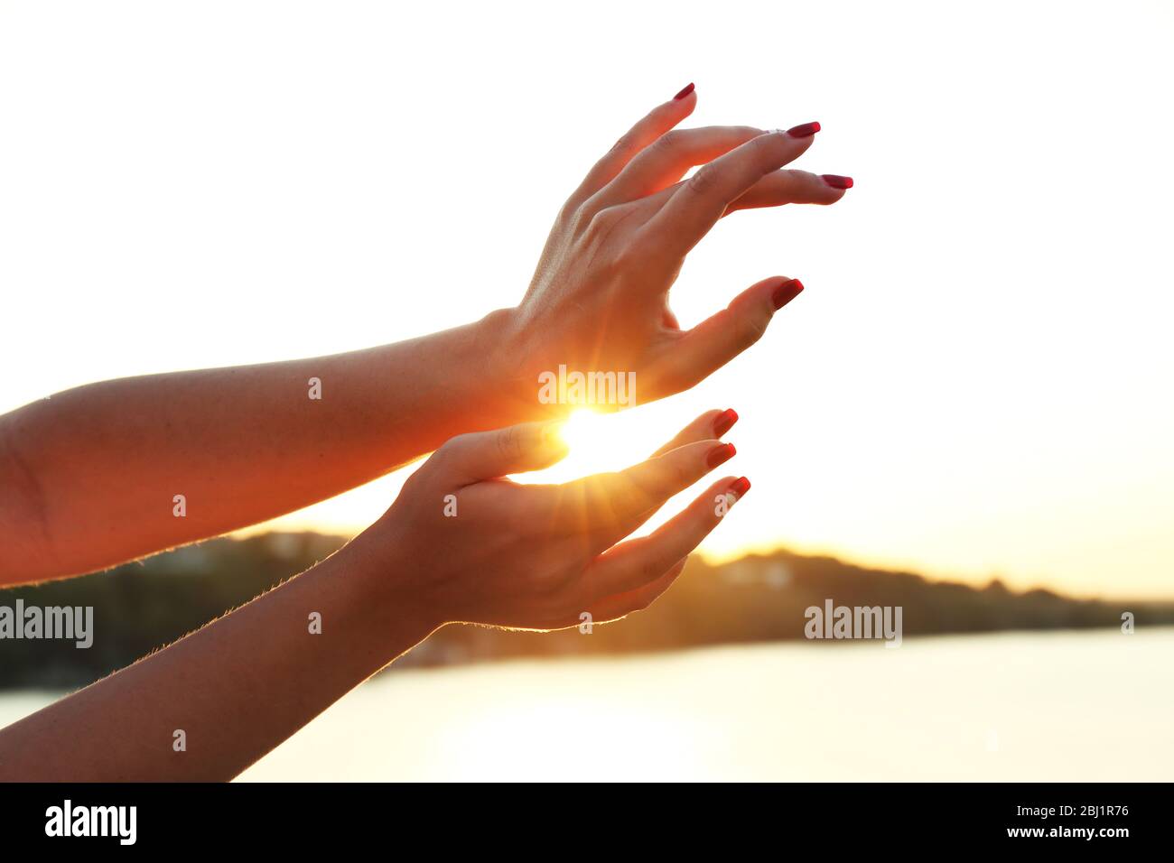 Female hands on sunny sky background Stock Photo - Alamy
