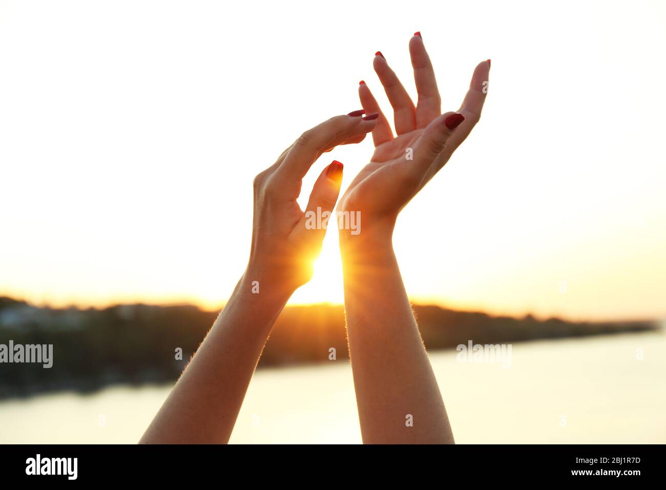 Female hands on sunny sky background Stock Photo - Alamy