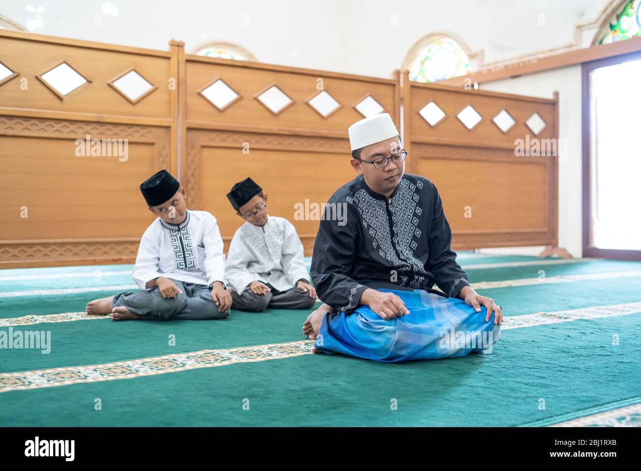 father and son praying together in the mosque. muslim people pray Stock Photo