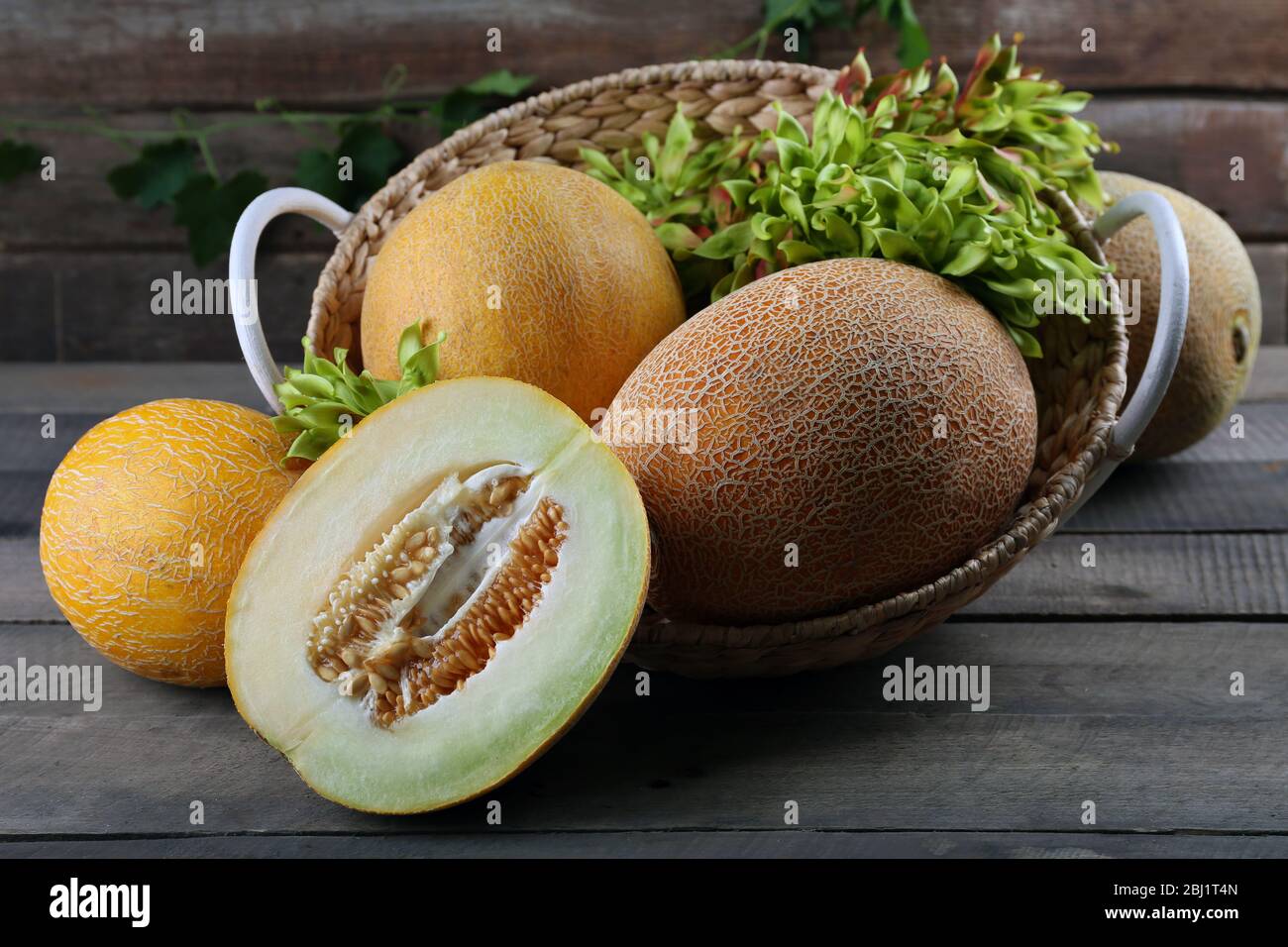 Ripe melons with green leaves in basket on table close up Stock Photo ...