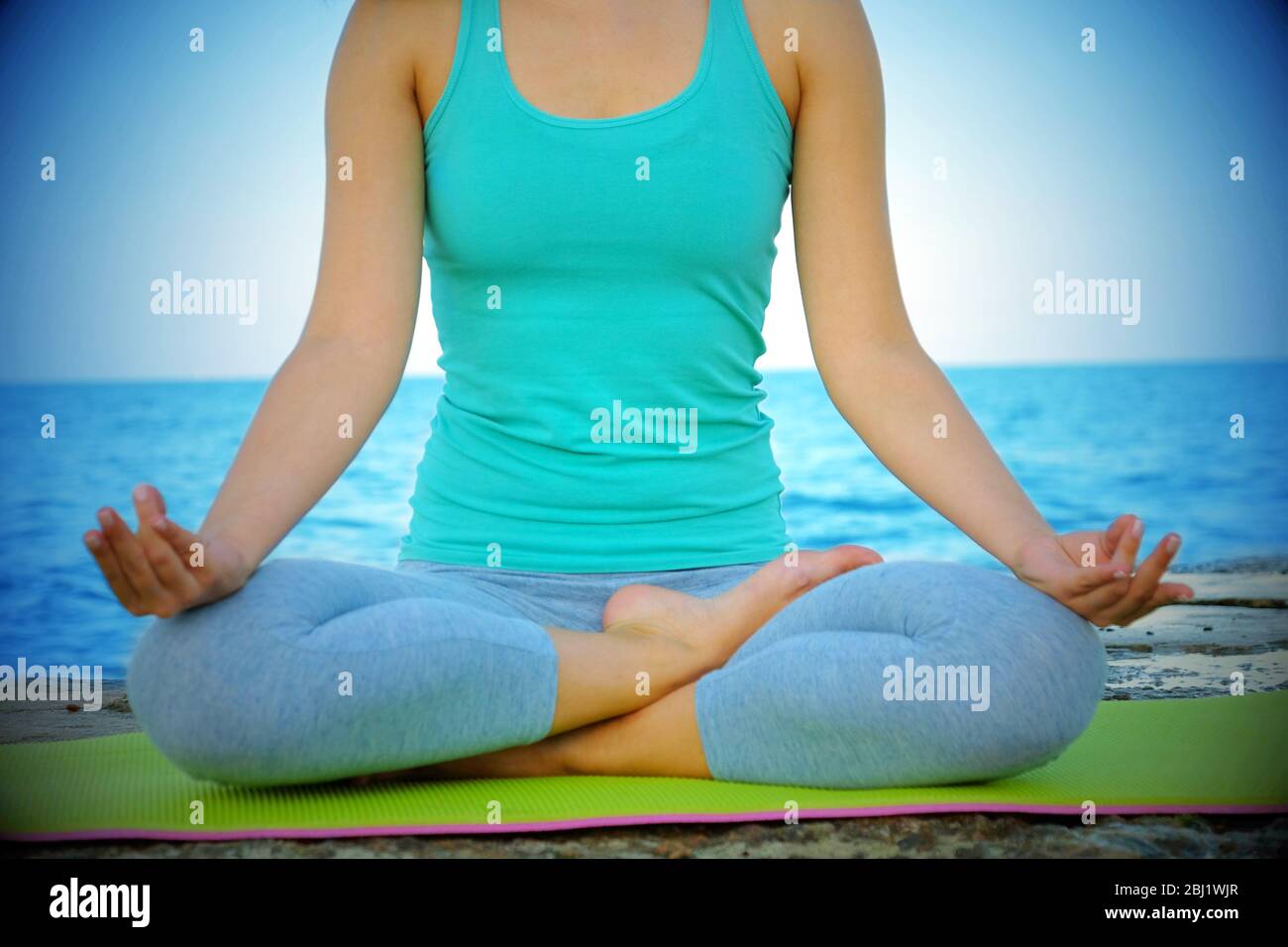 Young woman practicing yoga at seashore Stock Photo - Alamy