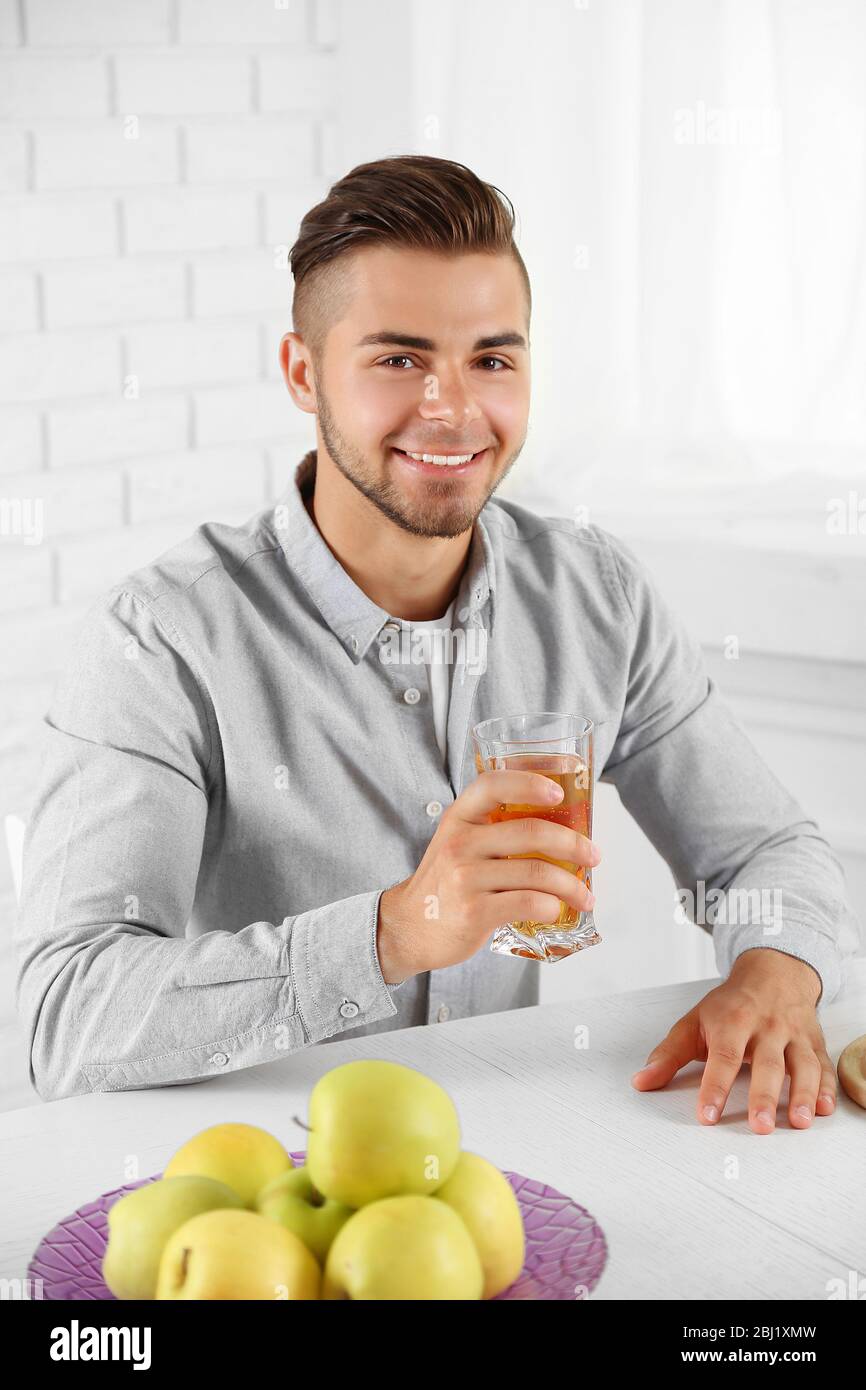 Young man showing glass of apple juice Stock Photo Alamy