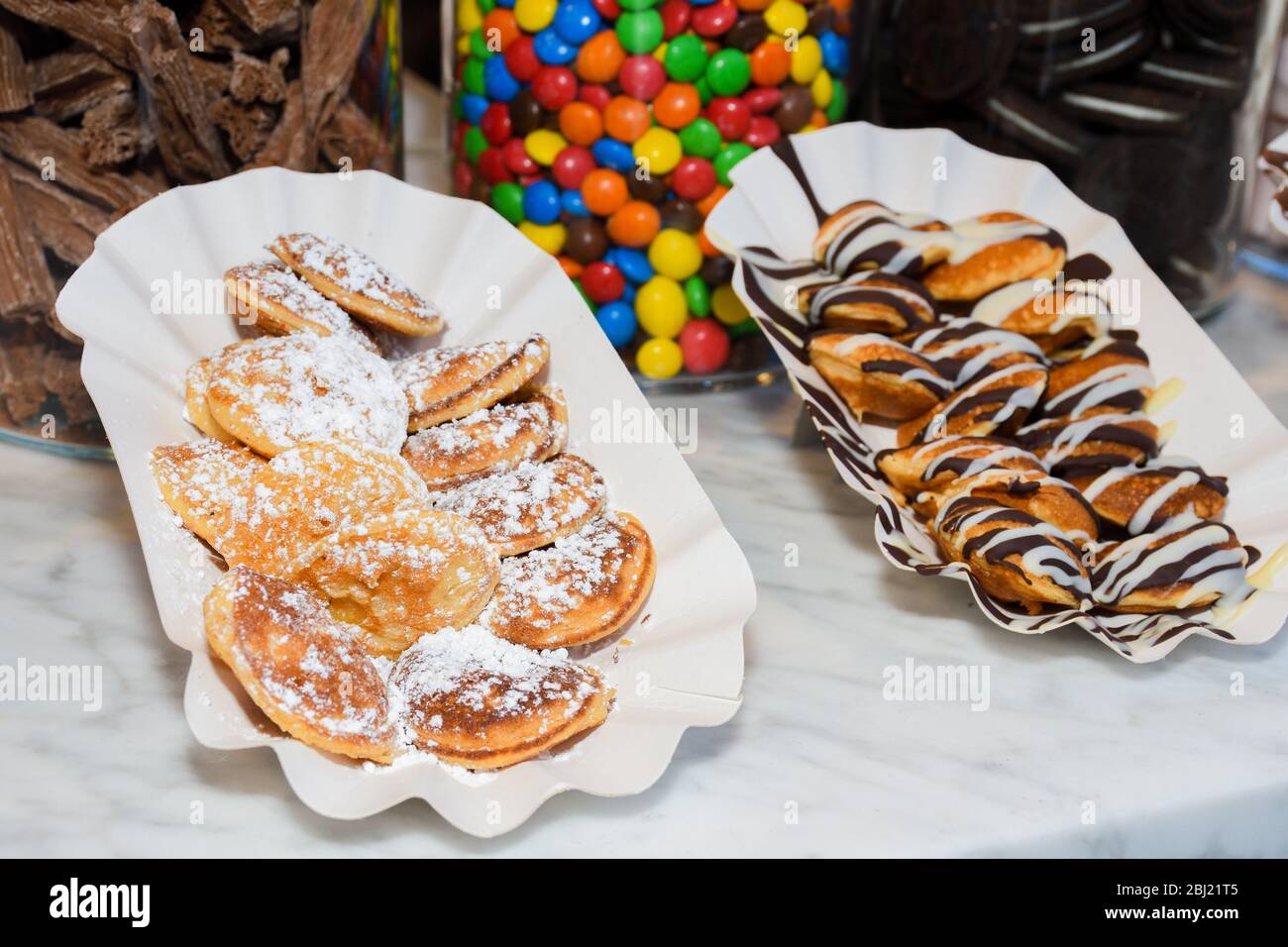 Street food dessert waffles and small pancakes with varied toppings