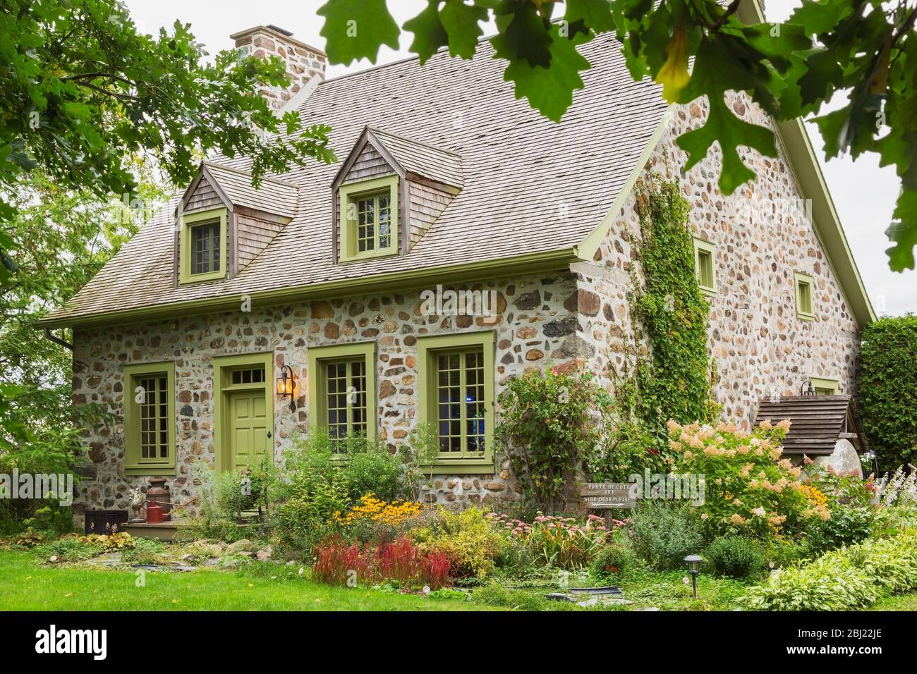 Exterior view of idyllic stone cottage with pretty garden in Canada. Stock Photo