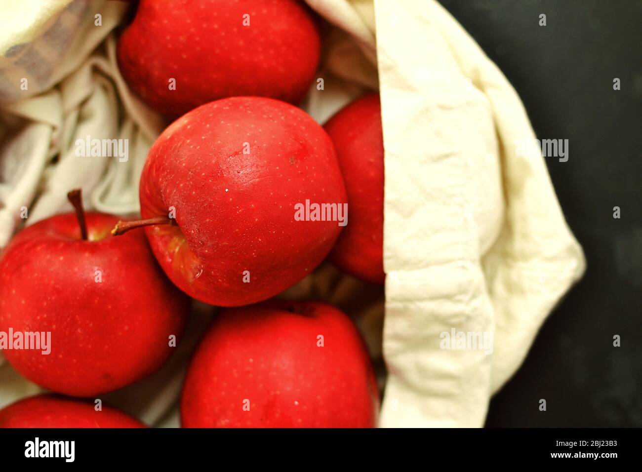Red apples in a cloth bag. Apples on a dark background in a cotton, linen bag. View from above. Dabinett Apple Stock Photo