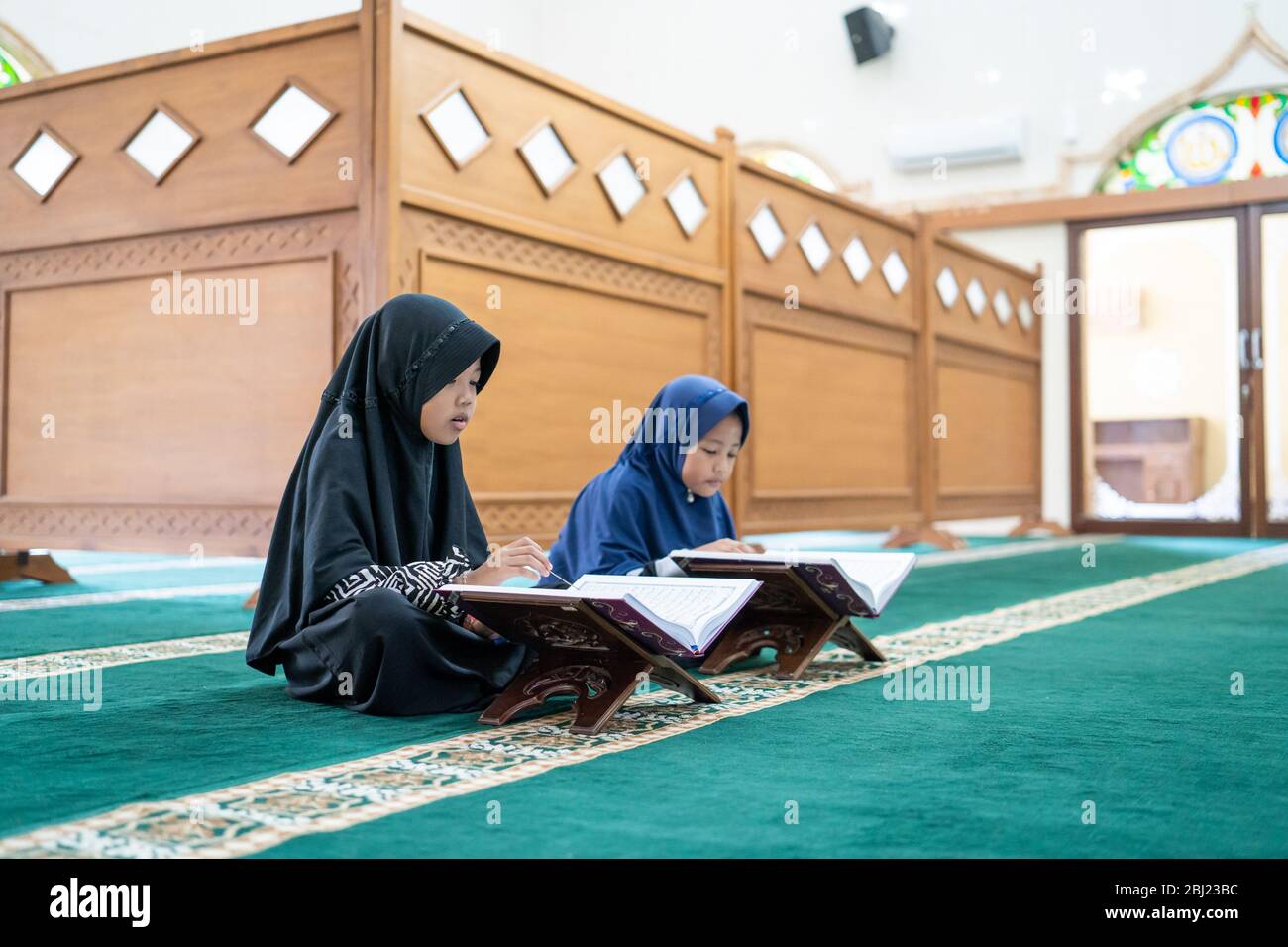 two kids read holy quran together in the mosque Stock Photo