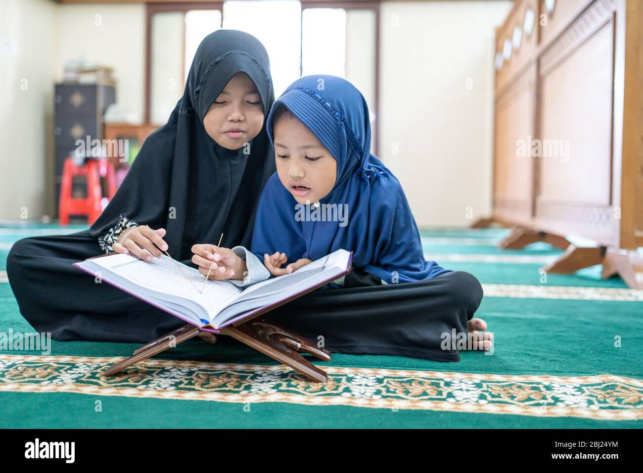 little girl muslim reading quran in the mosque during ramadan Stock Photo