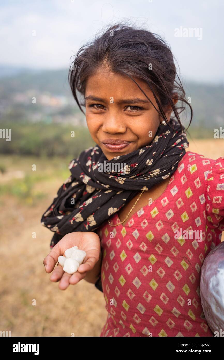 Jaflong / Bangladesh - January 28, 2019: Beautiful girl giving white stones to tourists and selling water as a way of making a living Stock Photo