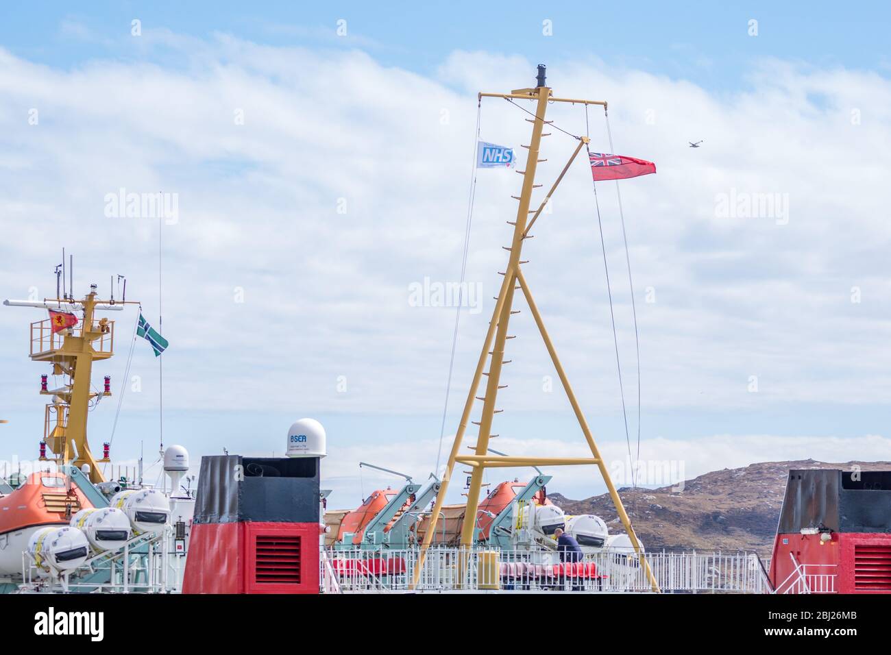 NHS, Thank you heroes flag, with red ensign flying on mast on Calmac Ferry Lord of the Isles in South Uist Outer Hebrides, Scotland Stock Photo