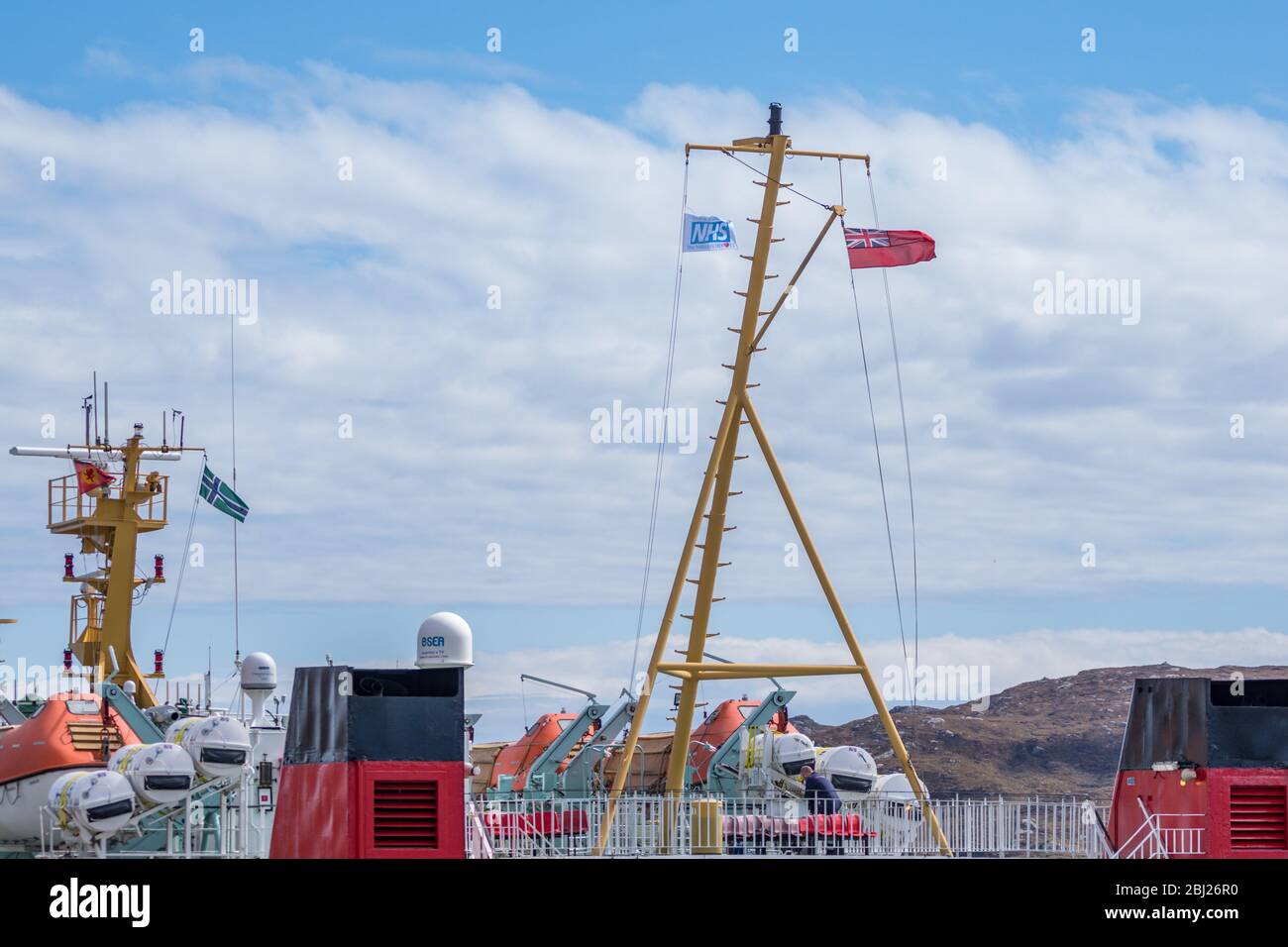 NHS, Thank you heroes flag, with red ensign flying on mast on Calmac Ferry Lord of the Isles in South Uist Outer Hebrides, Scotland Stock Photo