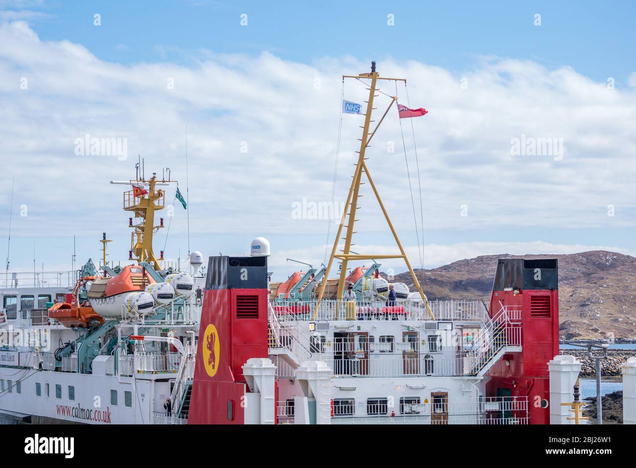 NHS, Thank you heroes flag, with red ensign flying on mast on Calmac Ferry Lord of the Isles in South Uist Outer Hebrides, Scotland Stock Photo