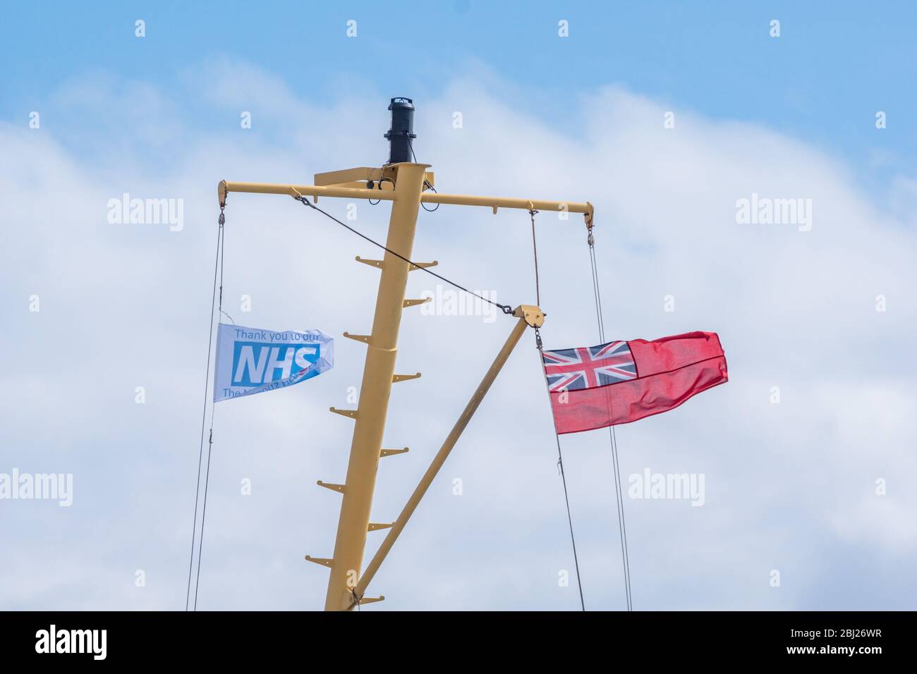 NHS, Thank you heroes flag, with red ensign flying on mast on Calmac Ferry Lord of the Isles in South Uist Outer Hebrides, Scotland Stock Photo