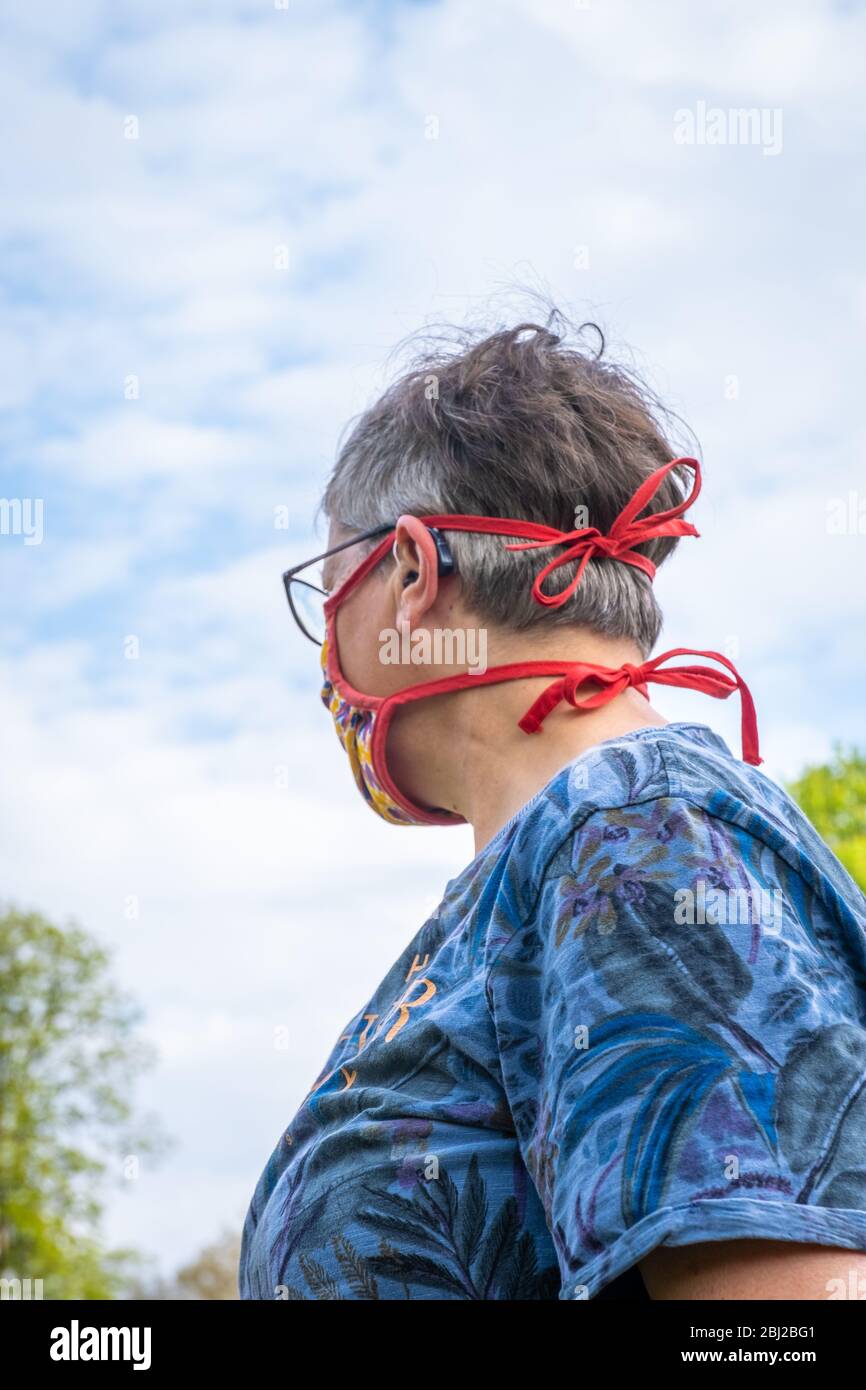 a woman from behind, wearing a face mask - outside Stock Photo