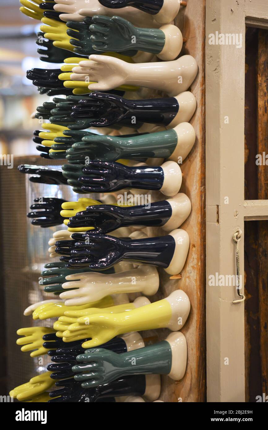 A display of ceramic jewelry holders in the shape of a hand. Inside the