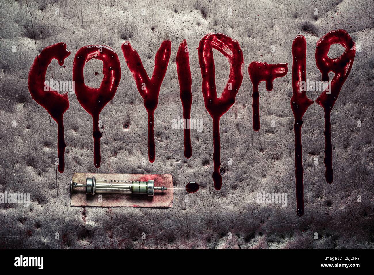Bloody and dripping word Covid19 and old syringe and needle Stock Photo