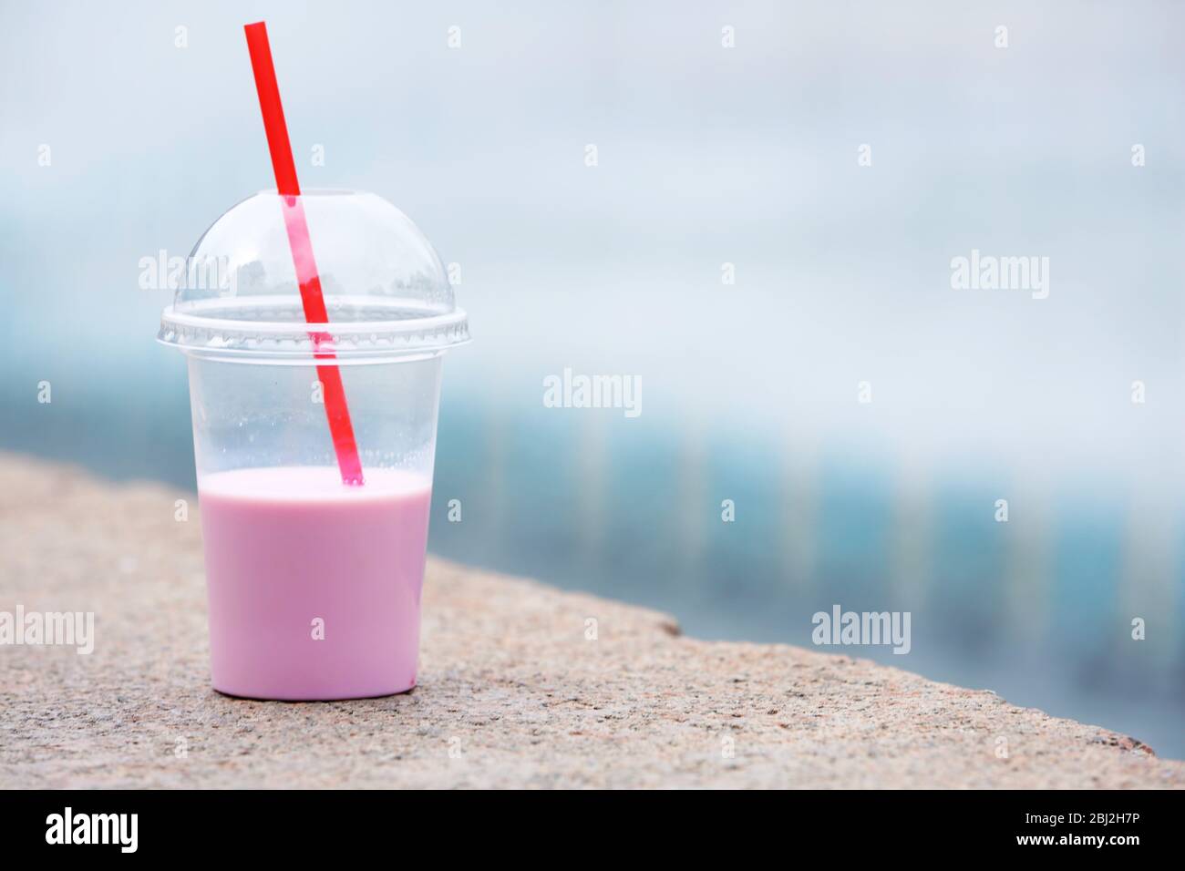 https://c8.alamy.com/comp/2BJ2H7P/plastic-cup-of-milkshake-on-light-background-outdoors-2BJ2H7P.jpg