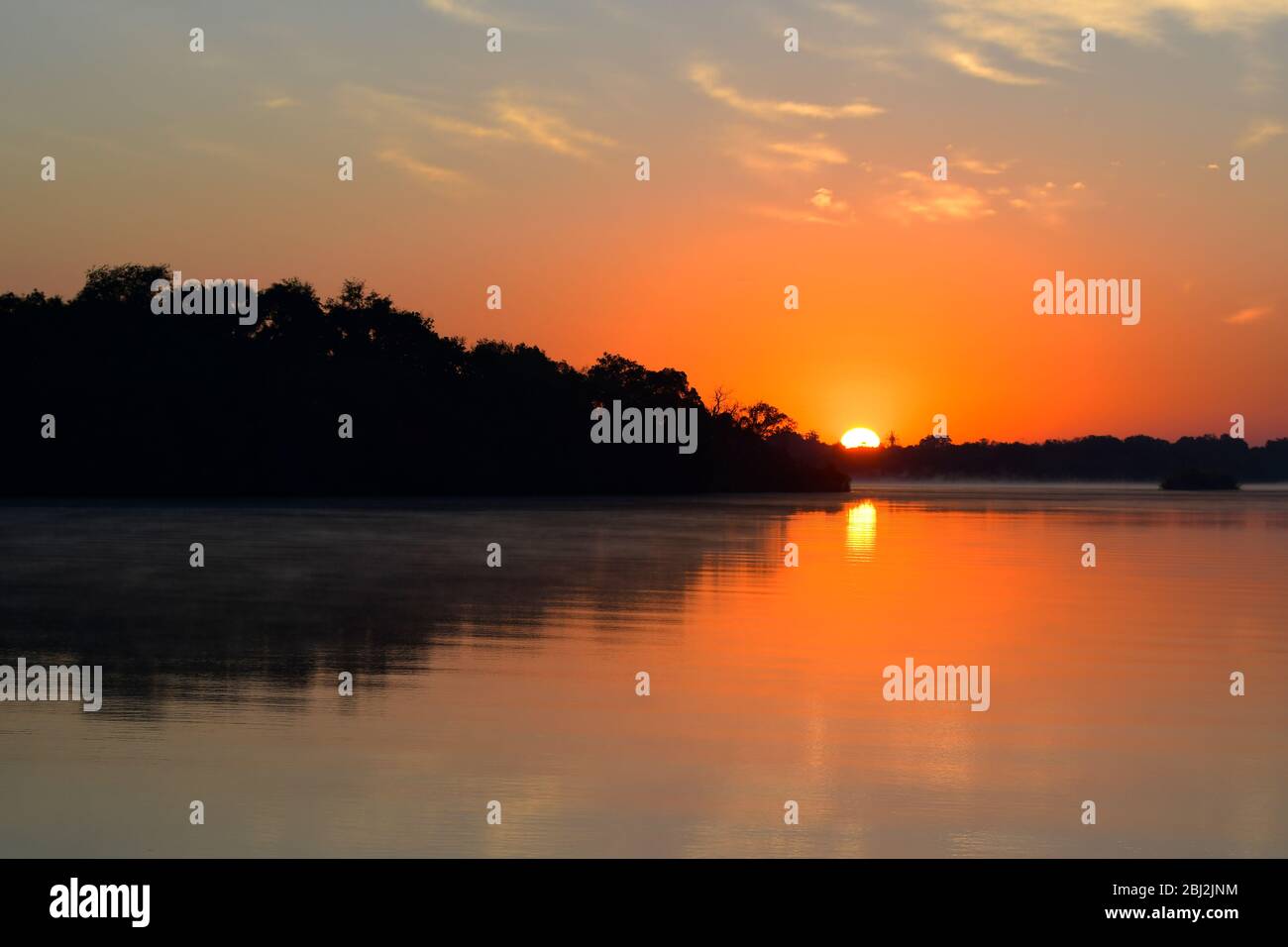 Sunrise on the calm Zambezi river near Victoria Falls, Zimbabwe Stock Photo