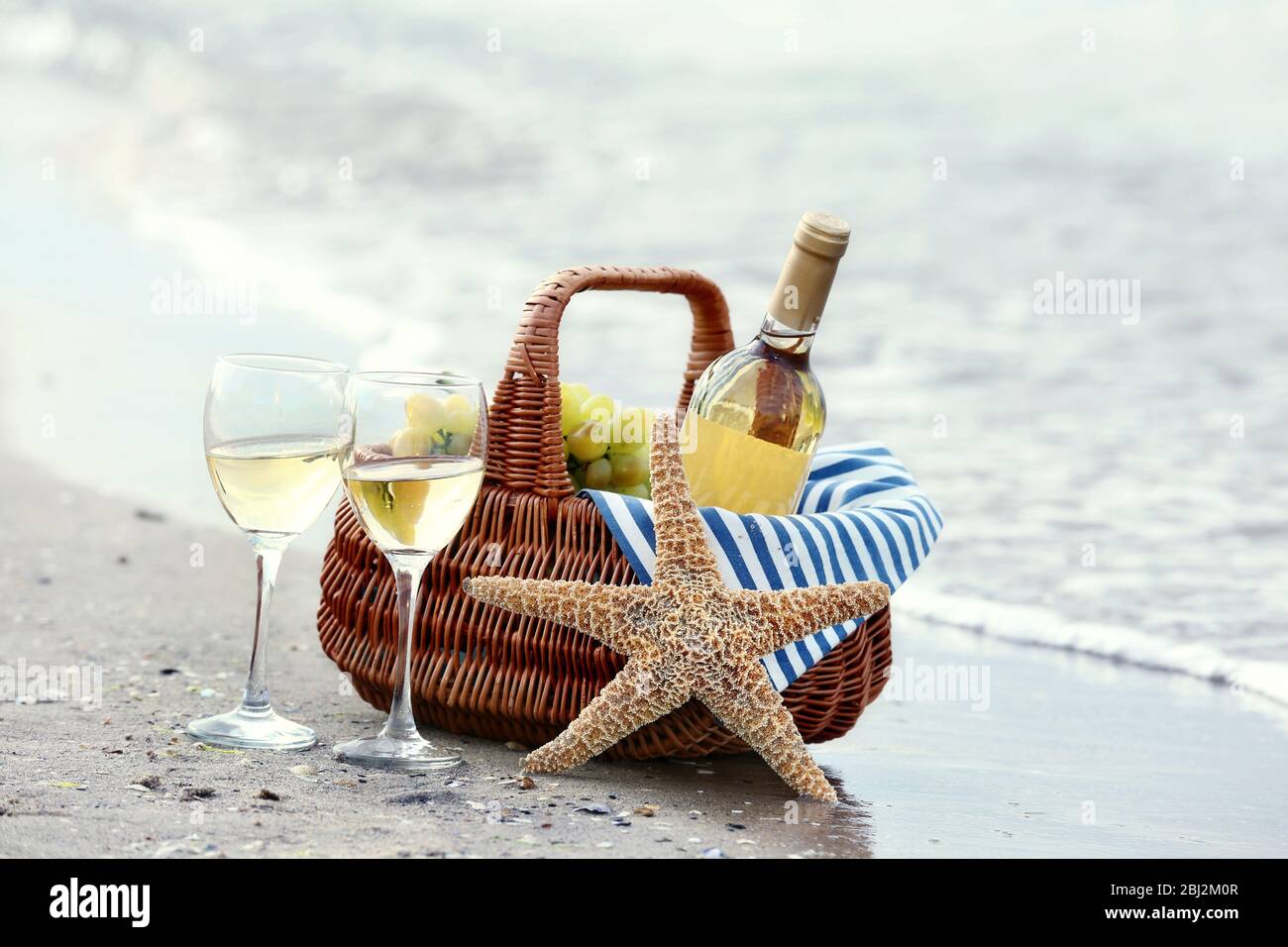 Picnic basket with bottle of wine on sand beach Stock Photo - Alamy