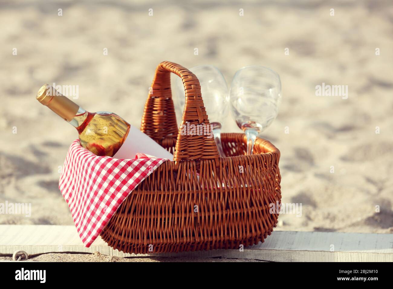 Picnic basket with bottle of wine on sand beach Stock Photo - Alamy
