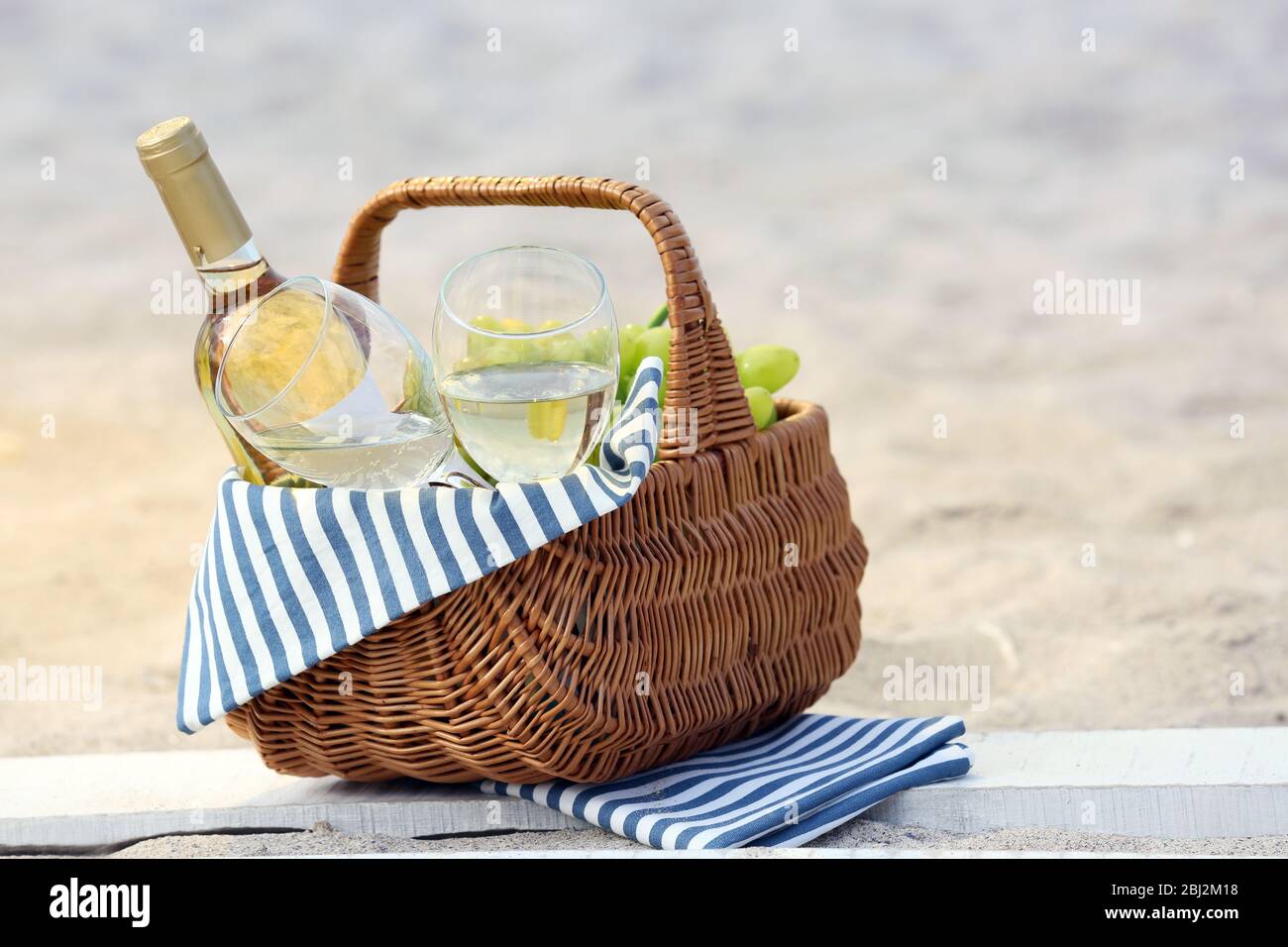 Picnic basket with bottle of wine on sand beach Stock Photo - Alamy