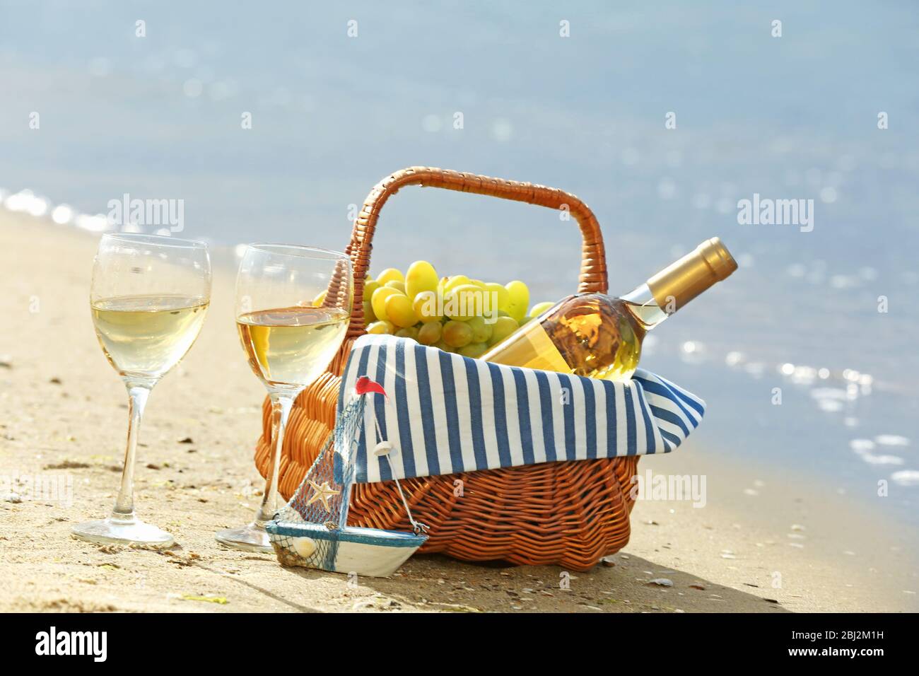 Picnic basket with bottle of wine on sand beach Stock Photo Alamy