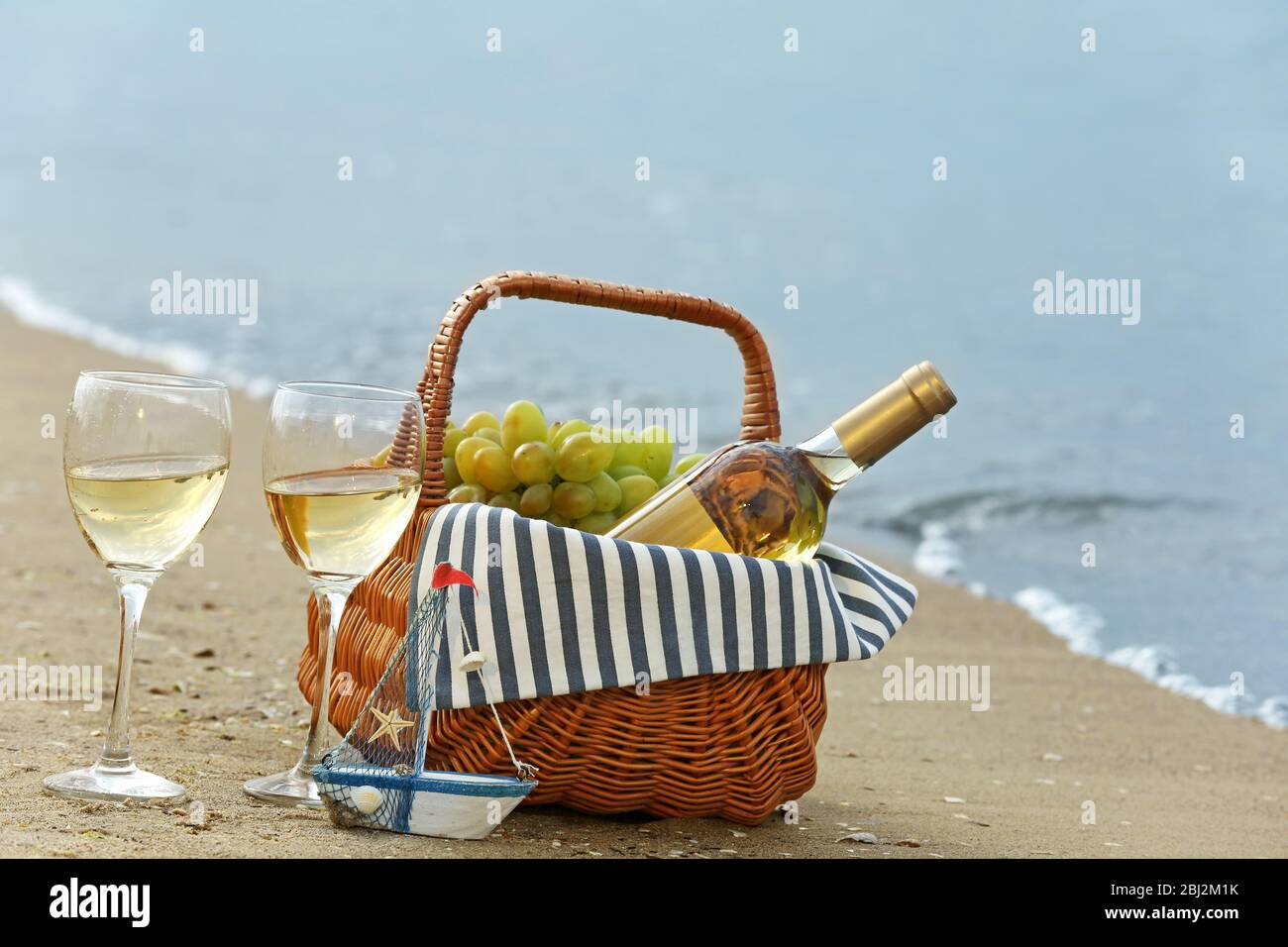 Picnic basket with bottle of wine on sand beach Stock Photo - Alamy