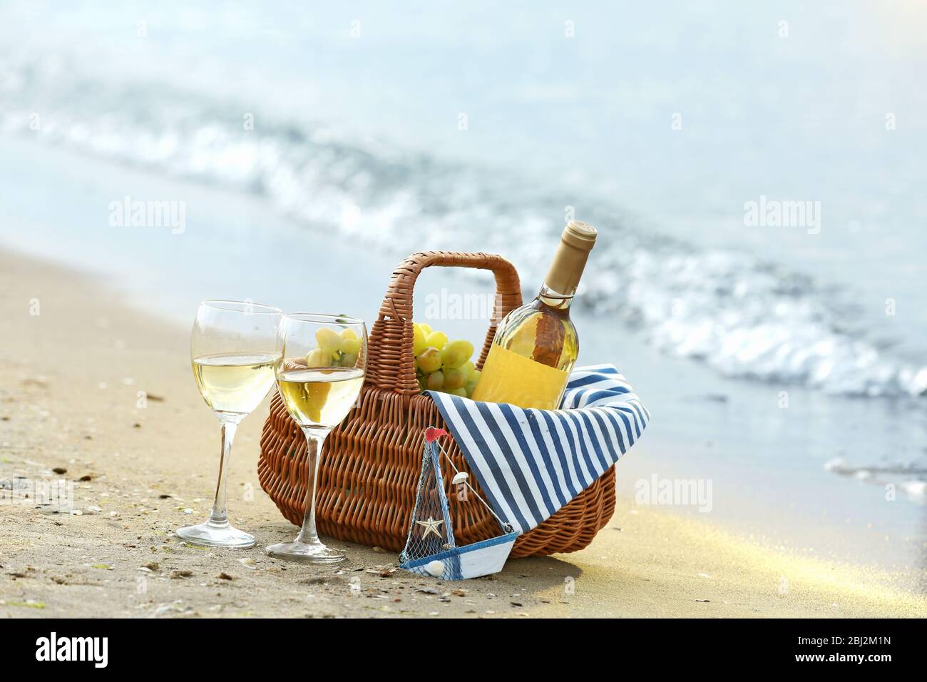 Picnic basket with bottle of wine on sand beach Stock Photo Alamy
