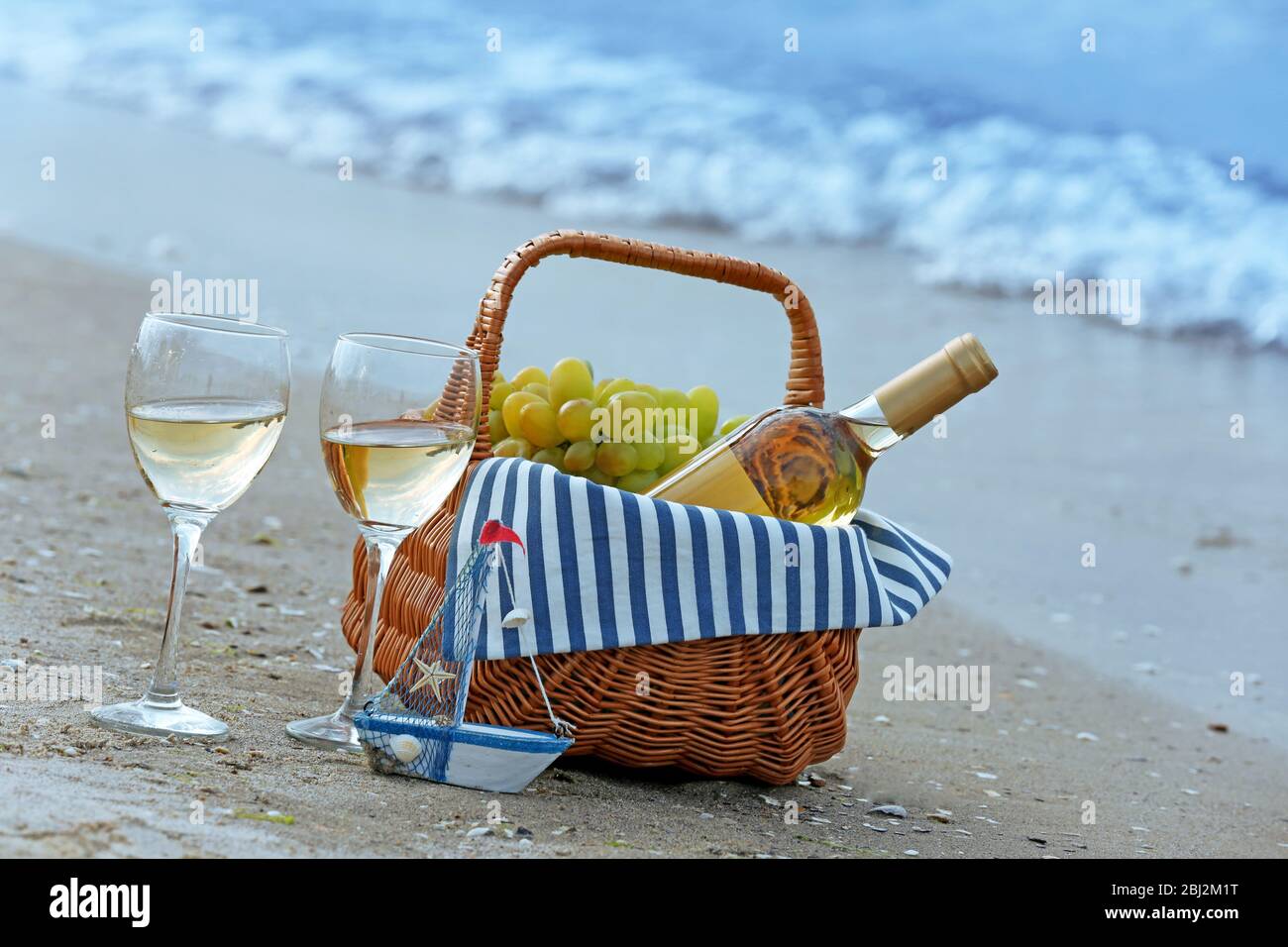 Picnic basket with bottle of wine on sand beach Stock Photo - Alamy