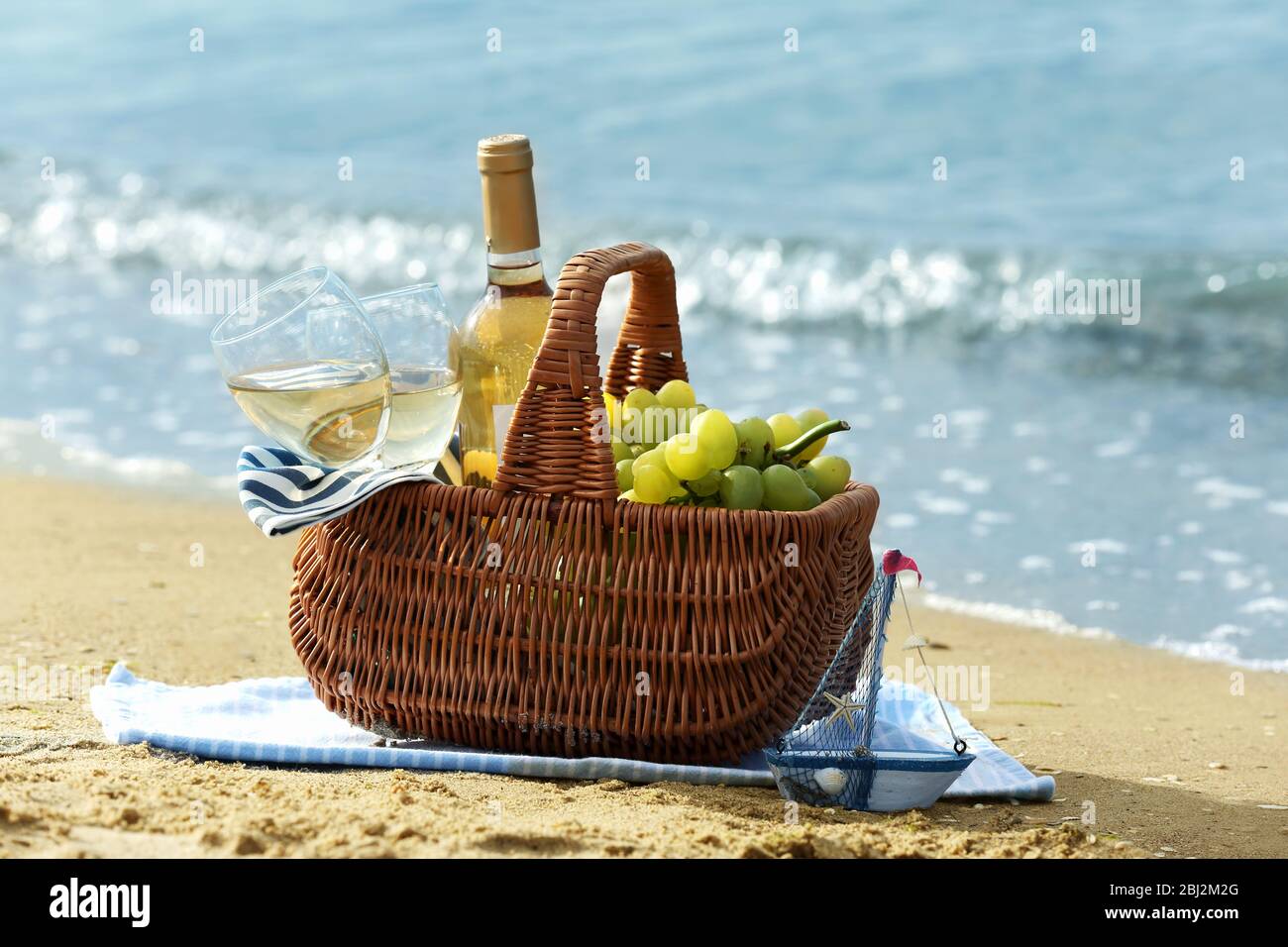 Picnic basket with bottle of wine on sand beach Stock Photo - Alamy