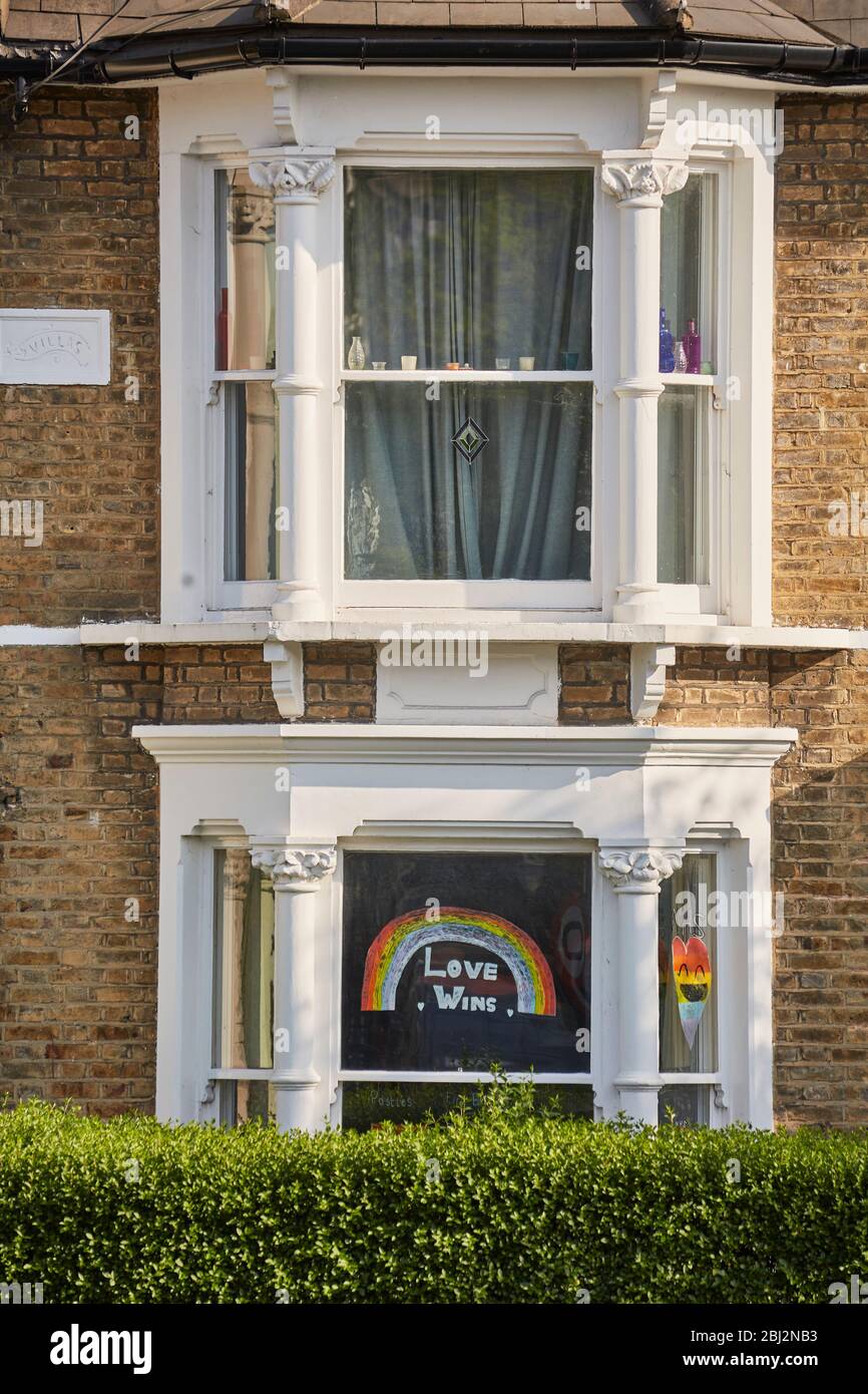 Child's Rainbow drawing with the words: 'Love Wins' for NHS workers diplayed in the Window, April 2020 during the Covid-19 outbreak Stock Photo