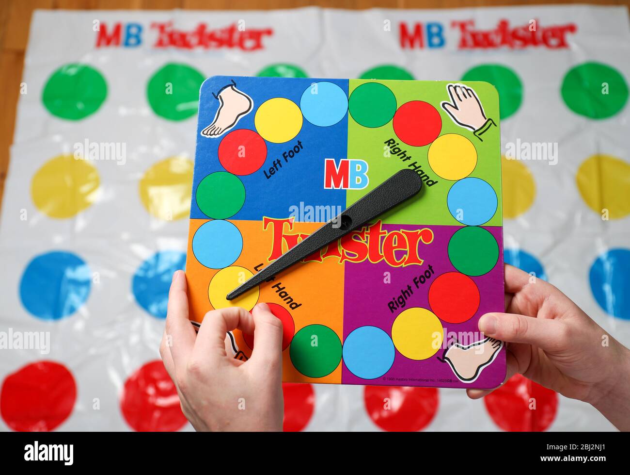 A boy spinning the twister game spinner before his go on the mat. Stock Photo
