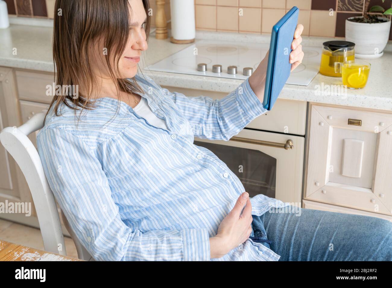 Female enjoys staying at home - watching movie, drinking tea Stock Photo