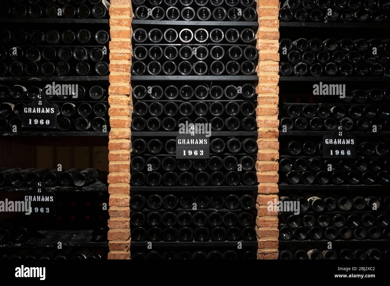Bottles of vintage port 1960, 1963, 1966, in racks at wine cellars of Graham's Port Lodge in V|la Nova de Gaia in Porto, Portugal Stock Photo