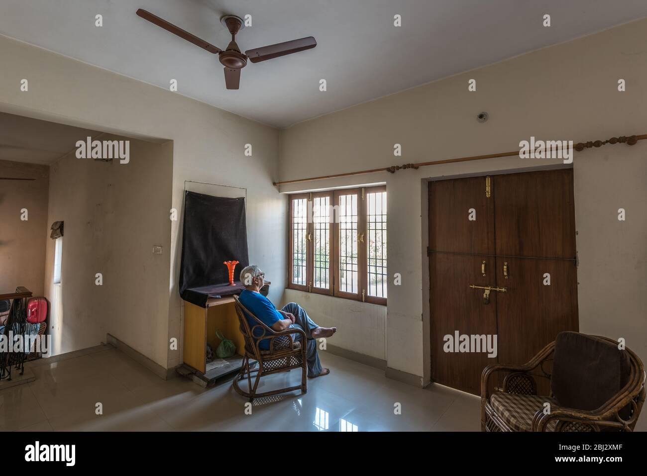 Senior citizen in home quarantine looking out of window for hope to go out during COVID-19 pandemic in Lucknow district , Uttar Pradesh, India Stock Photo