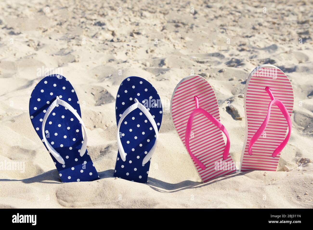 Flip flops on beach sand closeup Stock Photo - Alamy