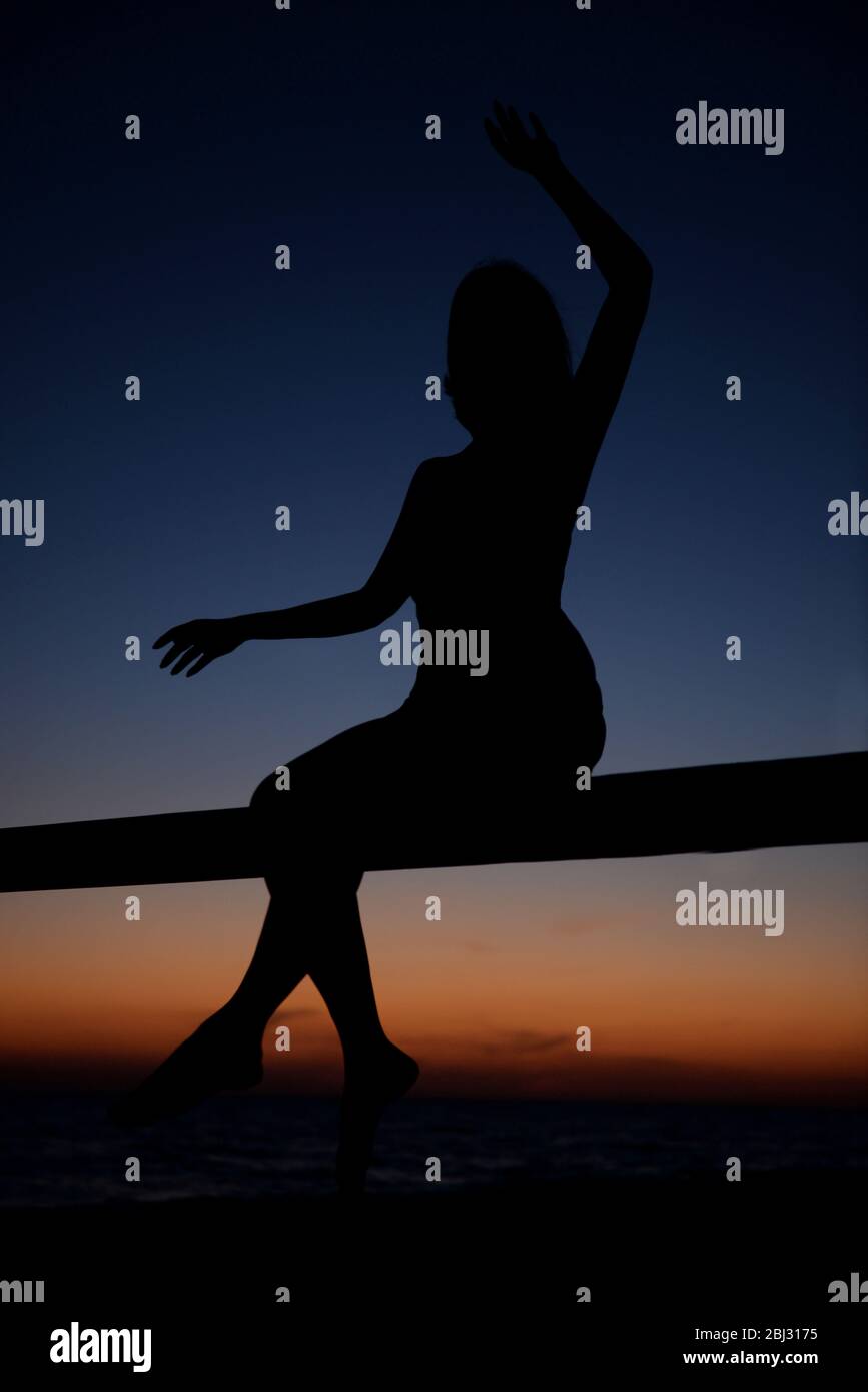 Woman silhouette on sunset sky background Stock Photo - Alamy
