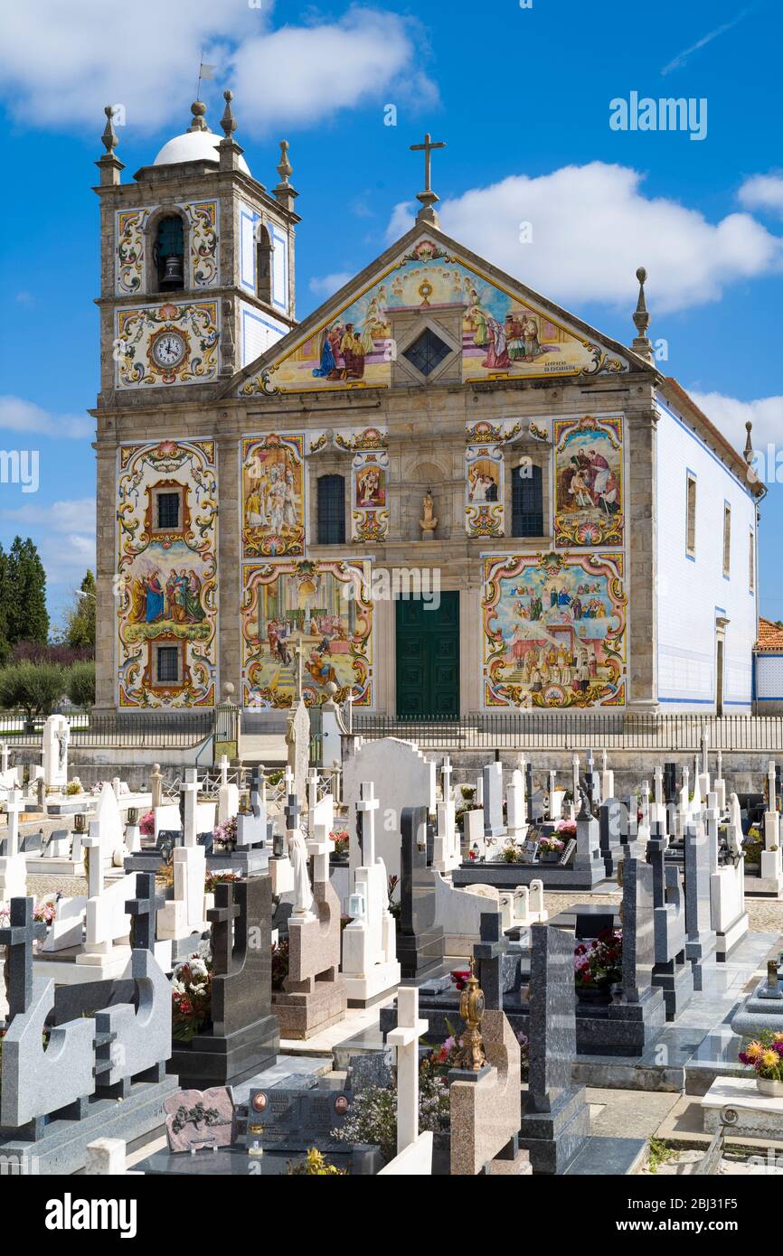 Church decorated with traditional tiles depicting religious scenes and graveyard at Valega near Ovar in Portugal Stock Photo