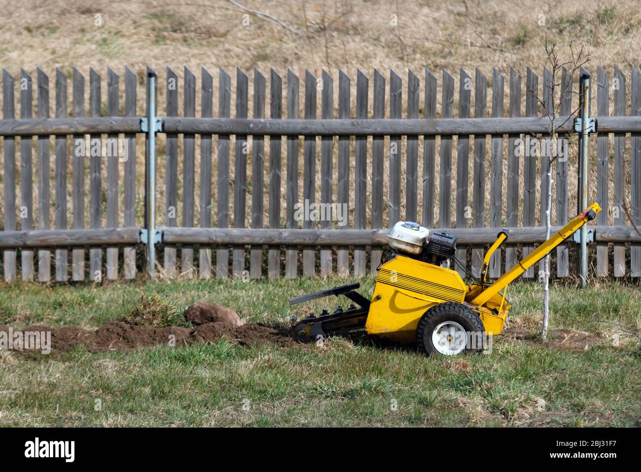 Excavator digging up soil to make watering system for plants in the