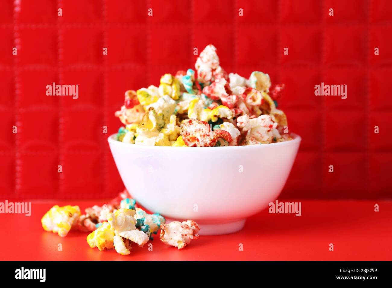 Sweet colourful popcorn on red background Stock Photo