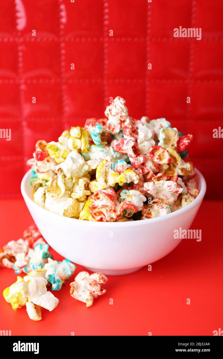 Sweet colourful popcorn on red background Stock Photo