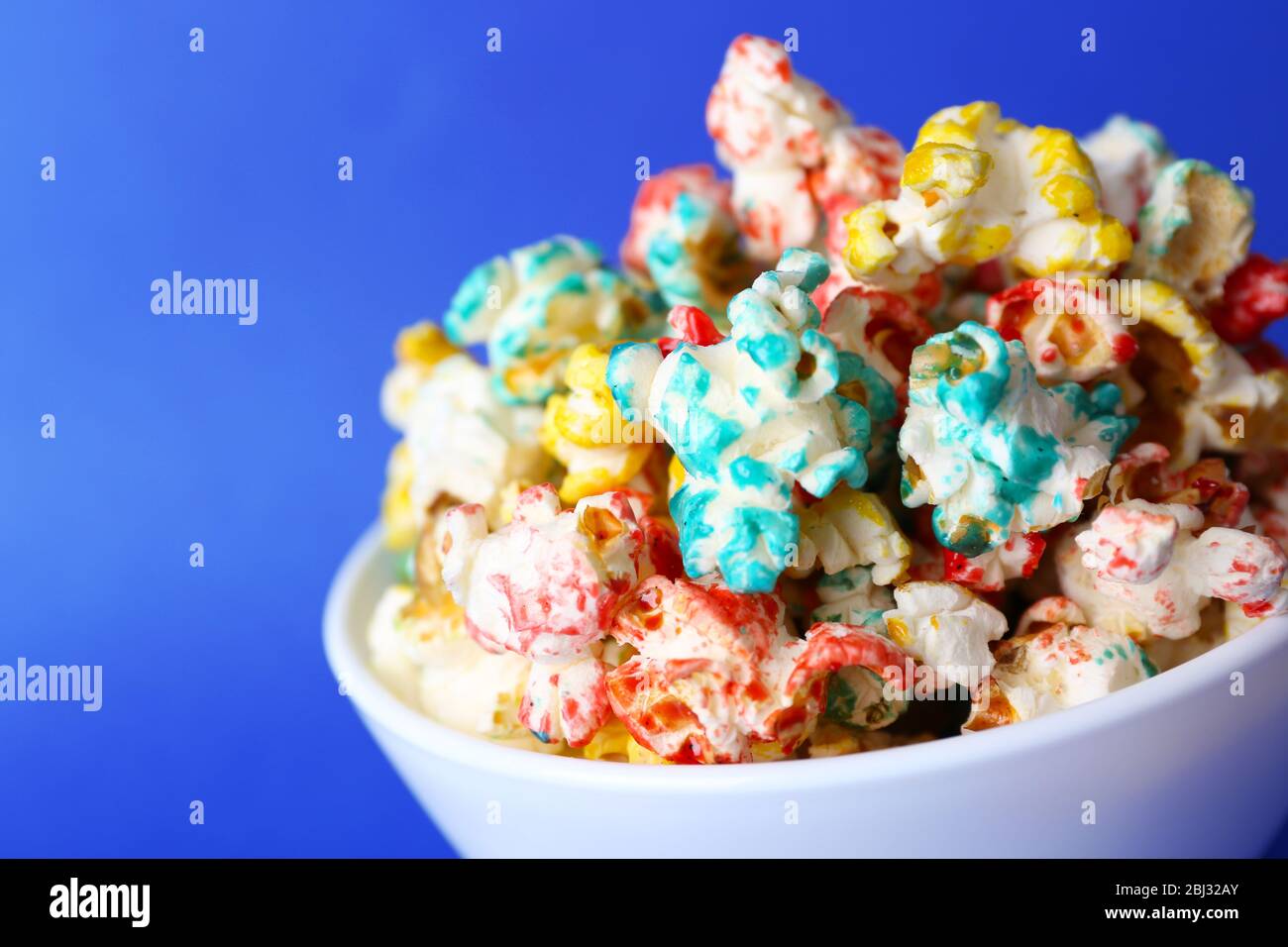 Sweet colourful popcorn on blue background Stock Photo