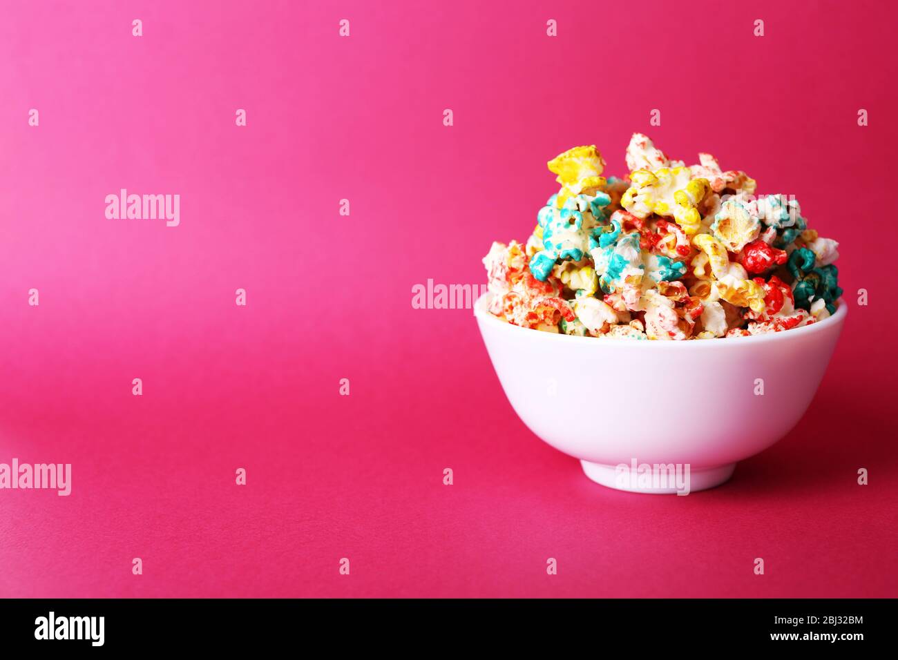 Sweet colourful popcorn on pink background Stock Photo