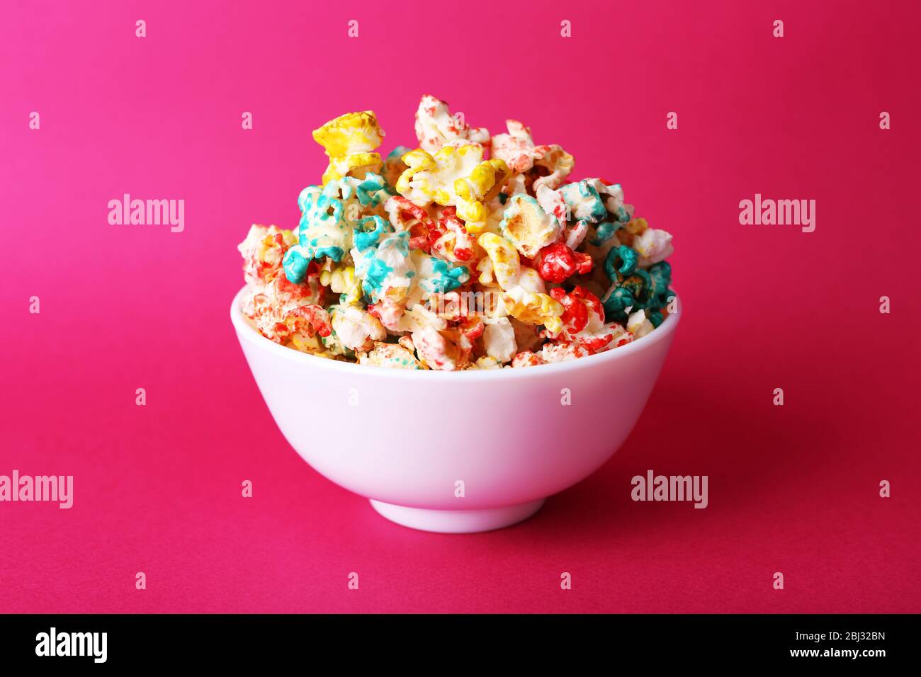 Sweet colourful popcorn on pink background Stock Photo